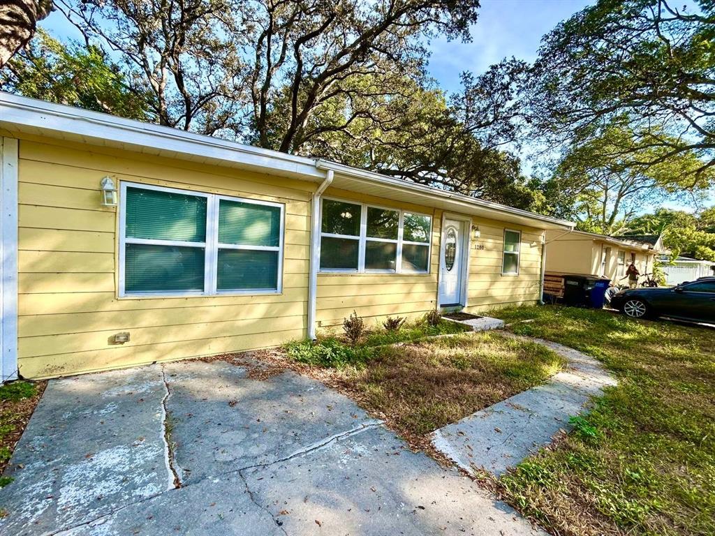 An empty room features light wood-look flooring, white walls, a ceiling fan, and a pass-through window — 1280 BERTLAND WAY, CLEARWATER, FL