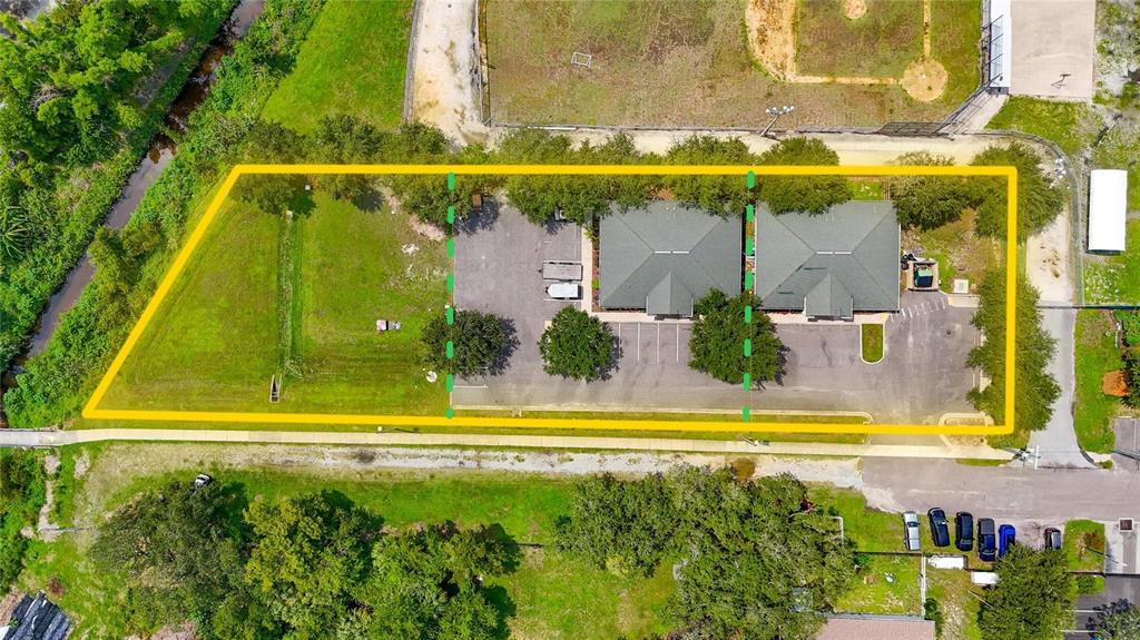 This aerial view shows two commercial buildings with parking lots on a large grassy lot — 7318 W COMANCHE AVENUE, TAMPA, FL