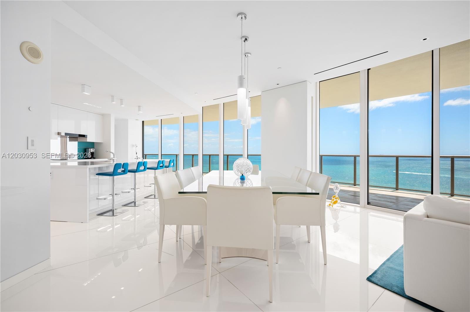 A bright dining area features a glass table, white chairs, and floor-to-ceiling ocean views — 9703 Collins Ave # 2000, Bal Harbour FL 33154, BAL HARBOUR, FL