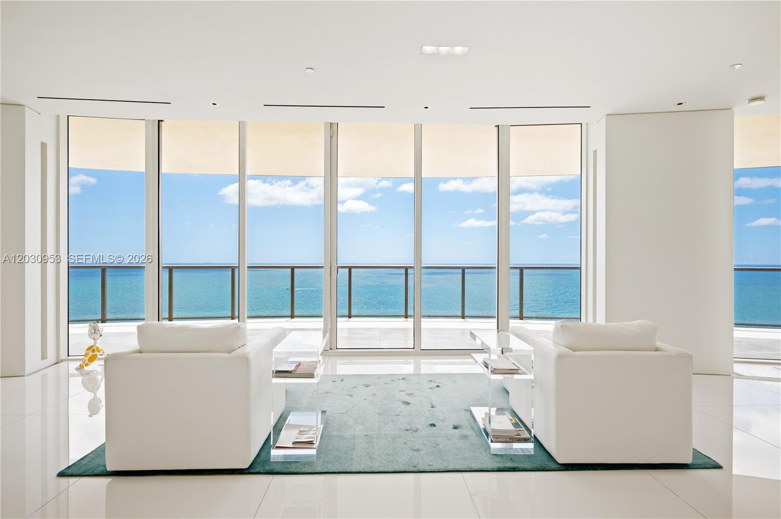 Two white armchairs face a floor-to-ceiling window wall overlooking the ocean — 9703 Collins Ave # 2000, Bal Harbour FL 33154, BAL HARBOUR, FL