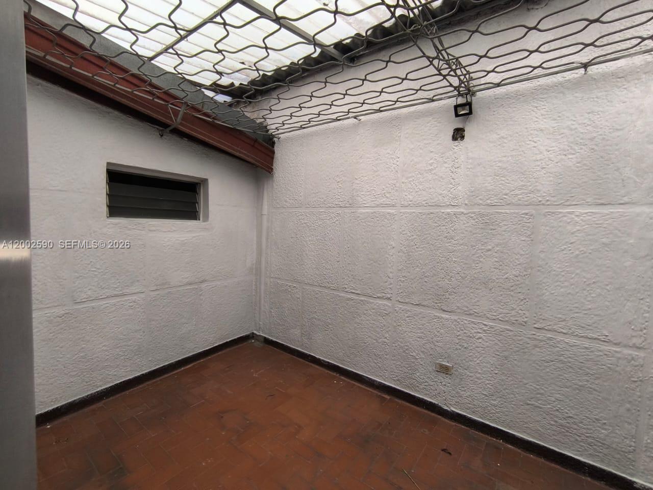 An enclosed patio features white textured walls, a tiled floor, and a metal grid ceiling — Cra. 79B 54-15 Barrio los Colores, FL, FL