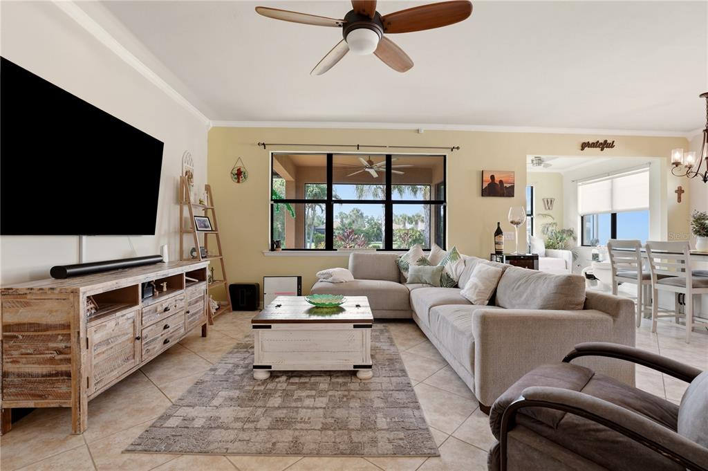 A living room features a large sectional sofa, a wooden media console, and a coffee table — 13920 KARINA STREET, VENICE, FL