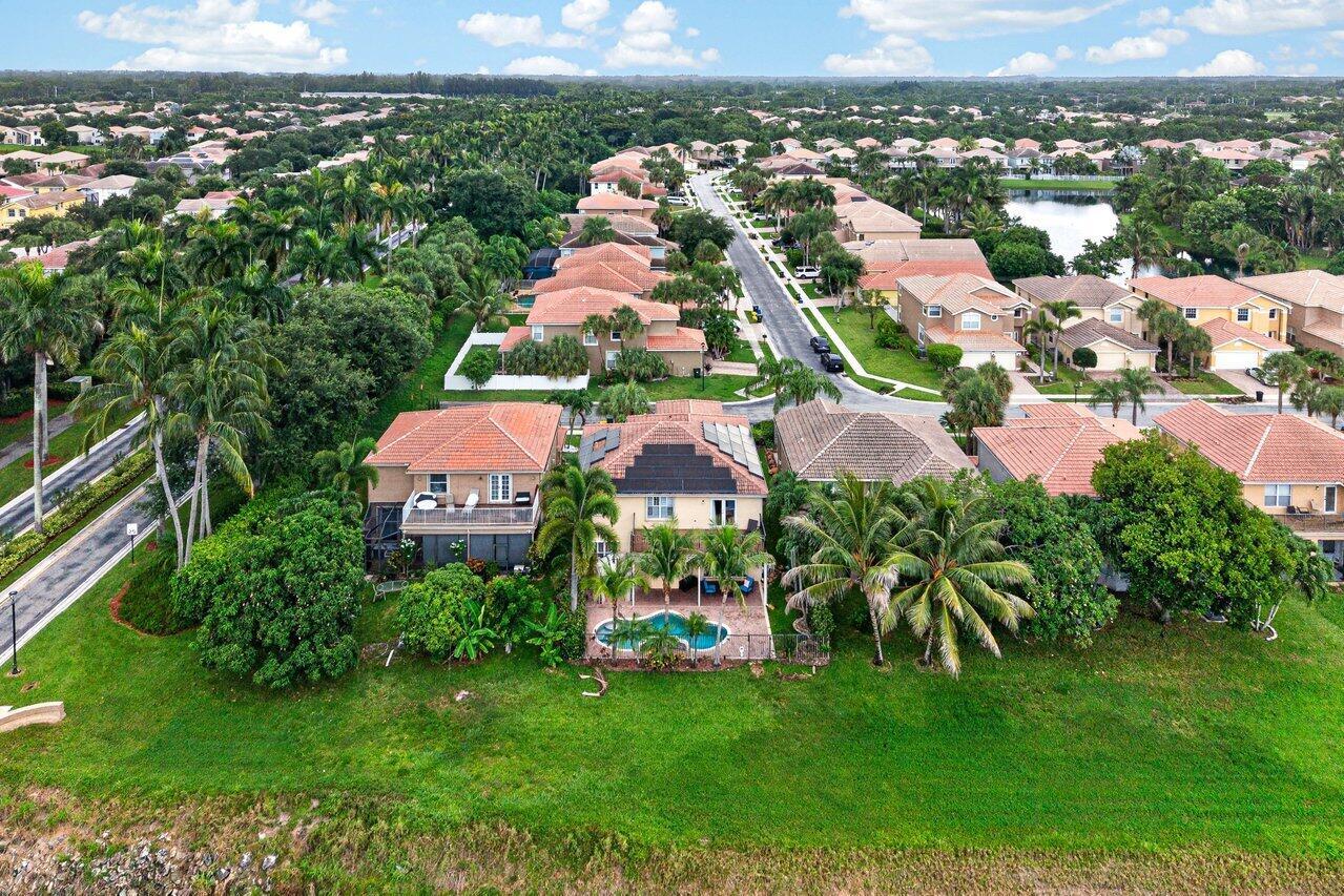 An aerial view of a suburban neighborhood featuring houses with tiled roofs and swimming pools — 5347 Island Gypsy Drive, FL 33463, FL