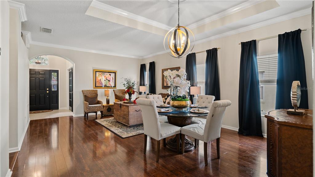 A dining area with a round table and chairs sits adjacent to a living space — 13560 HAWK LAKE DRIVE, ORLANDO, FL