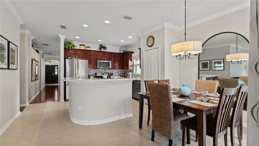 A kitchen with dark wood cabinets and a breakfast bar overlooks a dining area — 13560 HAWK LAKE DRIVE, ORLANDO, FL
