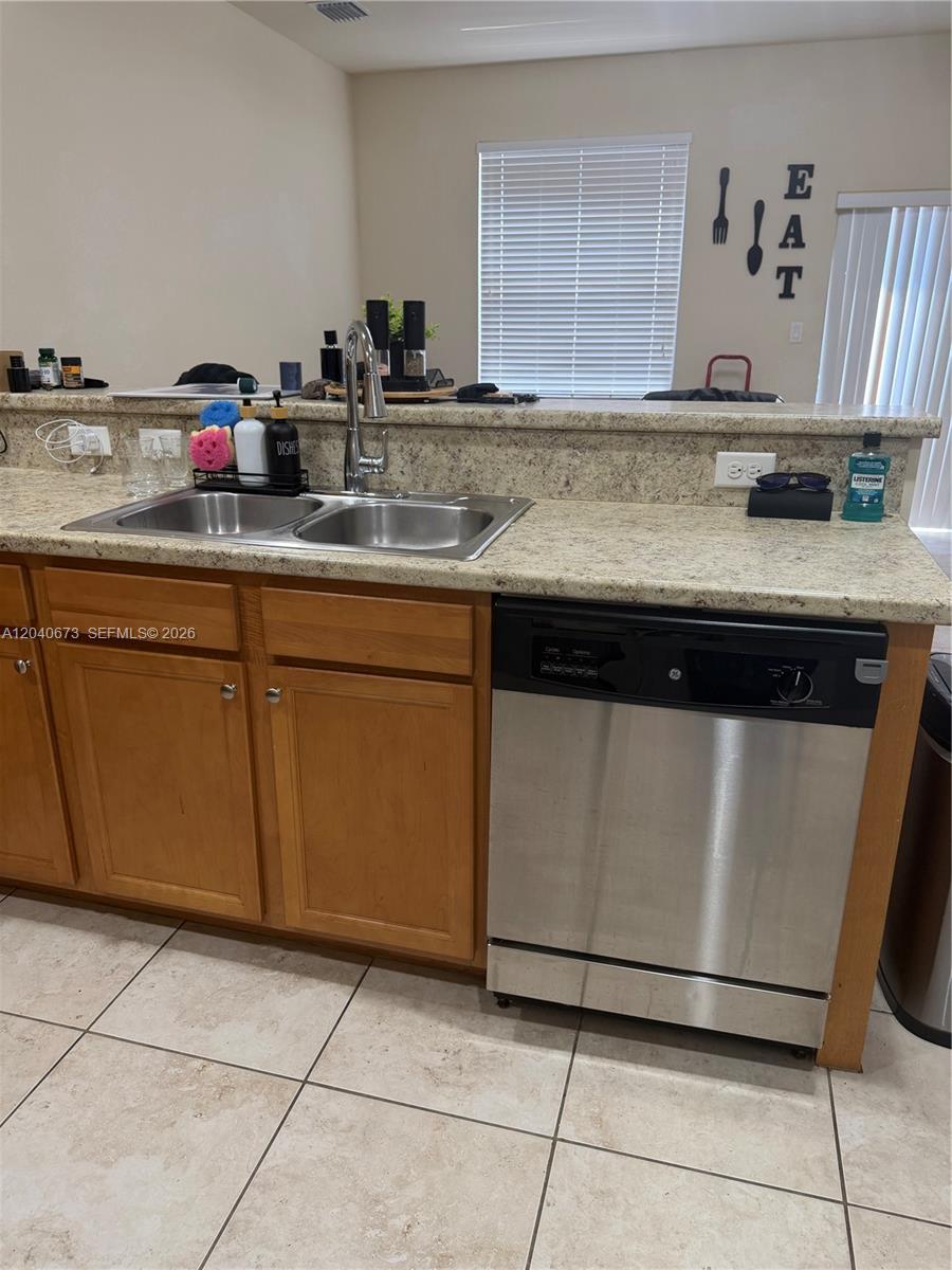 A kitchen features a stainless steel sink, a dishwasher, and light-colored granite countertops — 8929 W 35th Way, Hialeah FL 33018, HIALEAH, FL
