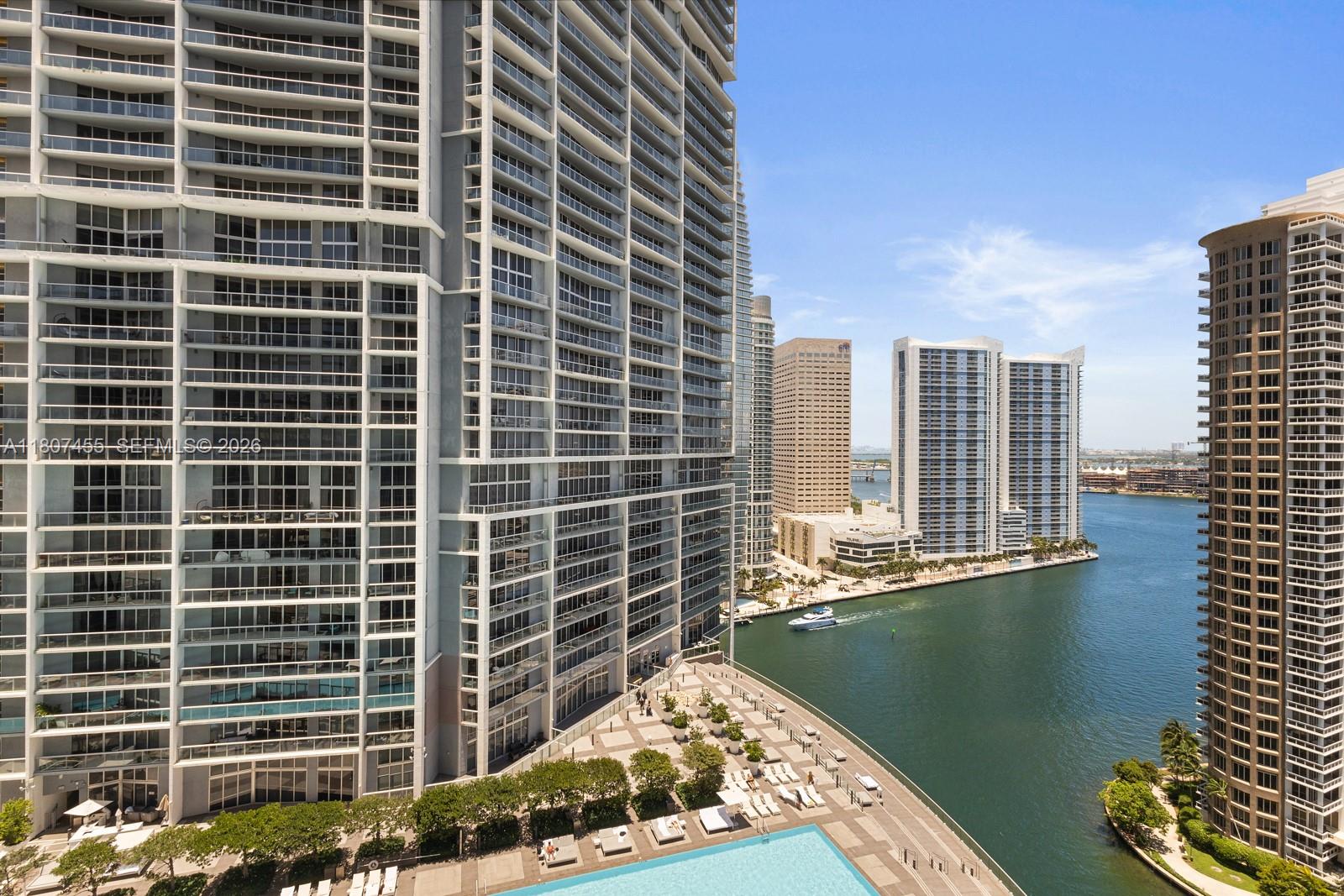 An elevated view of a high-rise apartment building exterior with a pool and waterfront — 495 Brickell Ave # 2304, Miami FL 33131, MIAMI, FL