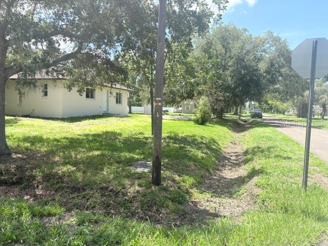 A single-story house with a light-colored exterior sits on a grassy lot with trees — 607 2ND STREET NW, RUSKIN, FL