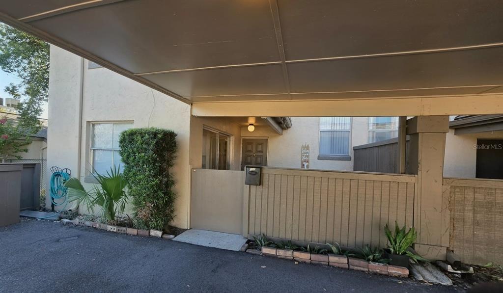 A covered carport leads to a gated entrance with a small patio and front door — 550 WINDMEADOWS STREET UNIT 550, ALTAMONTE SPRINGS, FL
