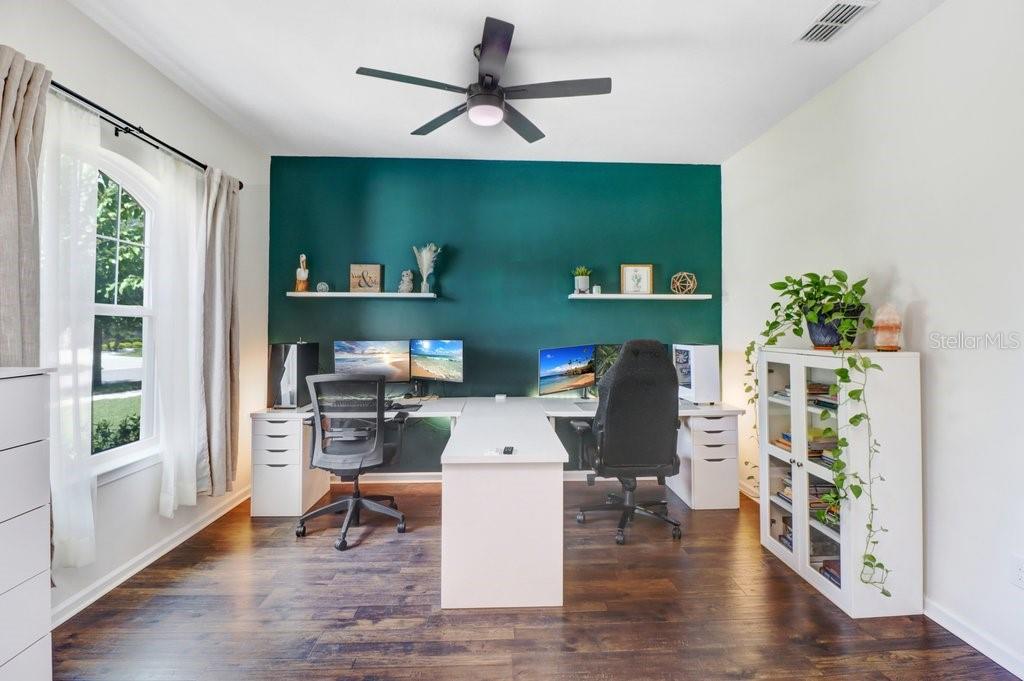 A home office features a dark green accent wall, dual desks, and a white bookcase — 11520 BLUE WOODS DRIVE, RIVERVIEW, FL