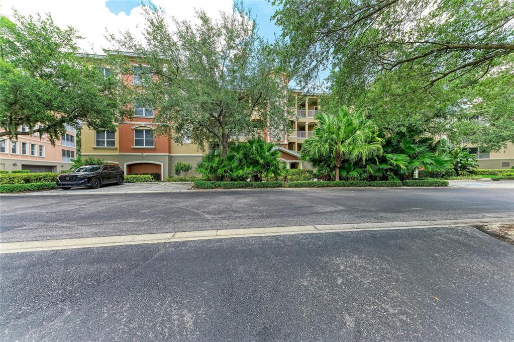 A multi-story apartment building with a parking area and lush landscaping in front — 5200 MANORWOOD DRIVE UNIT 2D, SARASOTA, FL