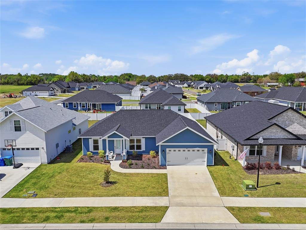 An aerial view shows a blue single-story suburban house with a two-car garage — 2168 SW 245TH DRIVE, NEWBERRY, FL