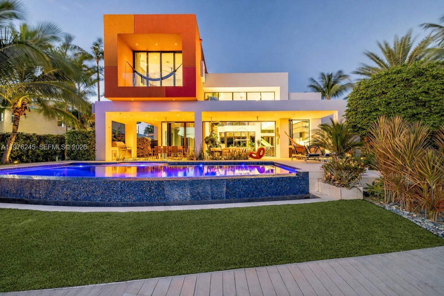 A modern two-story house with a vibrant orange facade, swimming pool, and landscaped backyard — 2101 NE 20th Ave, Wilton Manors FL 33305, WILTON MANORS, FL