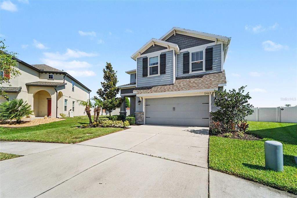 A two-story house with a gray exterior, a two-car garage, and a concrete driveway — 5463 LITTLE STREAM LANE, WESLEY CHAPEL, FL