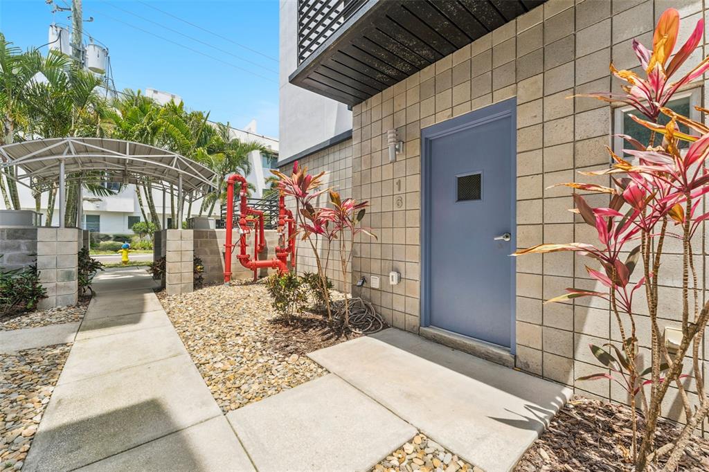 A blue door with a small window is set into a beige concrete block wall — 5008 S MACDILL AVENUE UNIT 16, TAMPA, FL