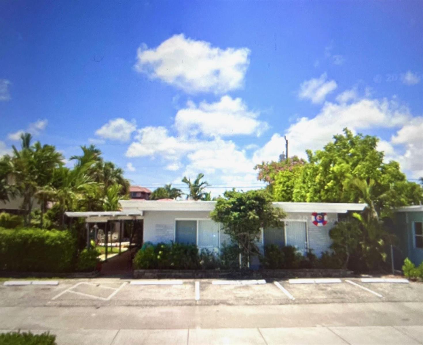 A single-story building with a flat roof, white exterior, and a small parking lot in front — FORT LAUDERDALE, FL