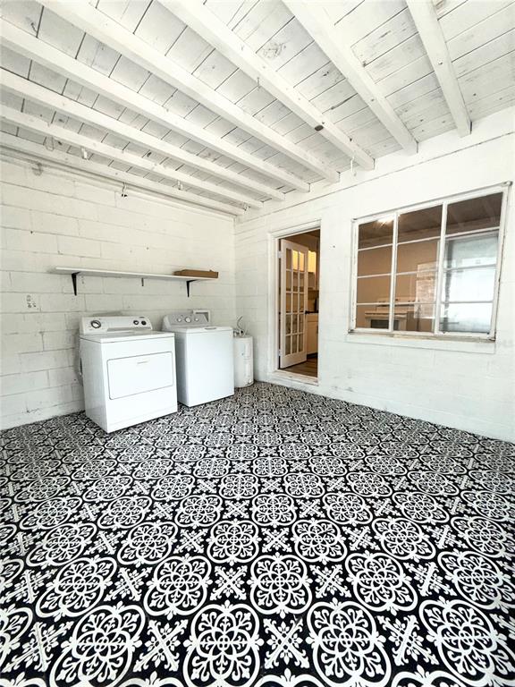 A laundry room features a patterned tile floor, white block walls, and a beamed ceiling — 1016 ALBA DRIVE UNIT 1016, ORLANDO, FL