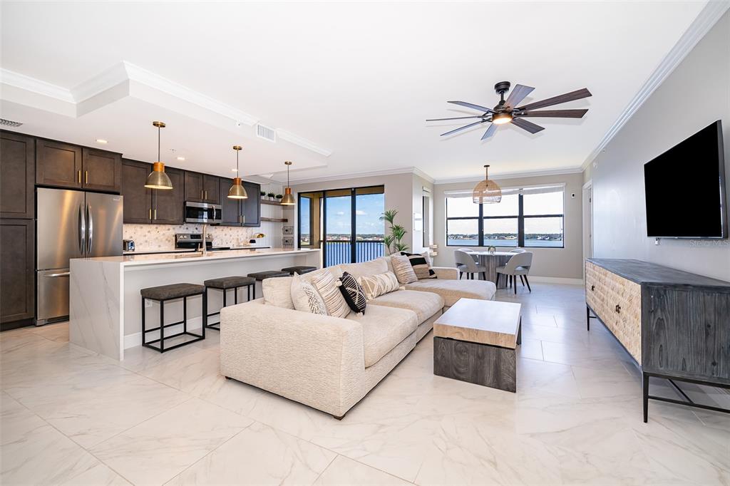 An open-concept living area features a modern kitchen with dark cabinets and a water view — 16300 COUNTY ROAD 455 UNIT 602, MONTVERDE, FL
