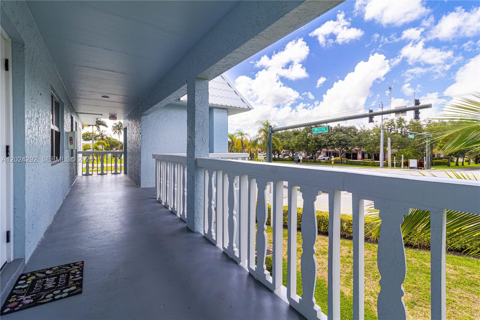 A covered balcony with a white railing overlooks a street intersection with traffic lights — 9780 N Marina Blvd # 424, Boca Raton FL 33428, BOCA RATON, FL