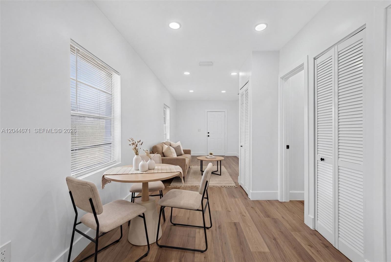 A bright, minimalist room features a small dining set, a sofa, and white louvered doors — 1900 SW 6th St SW 6th St # 6, Miami FL 33135, MIAMI, FL