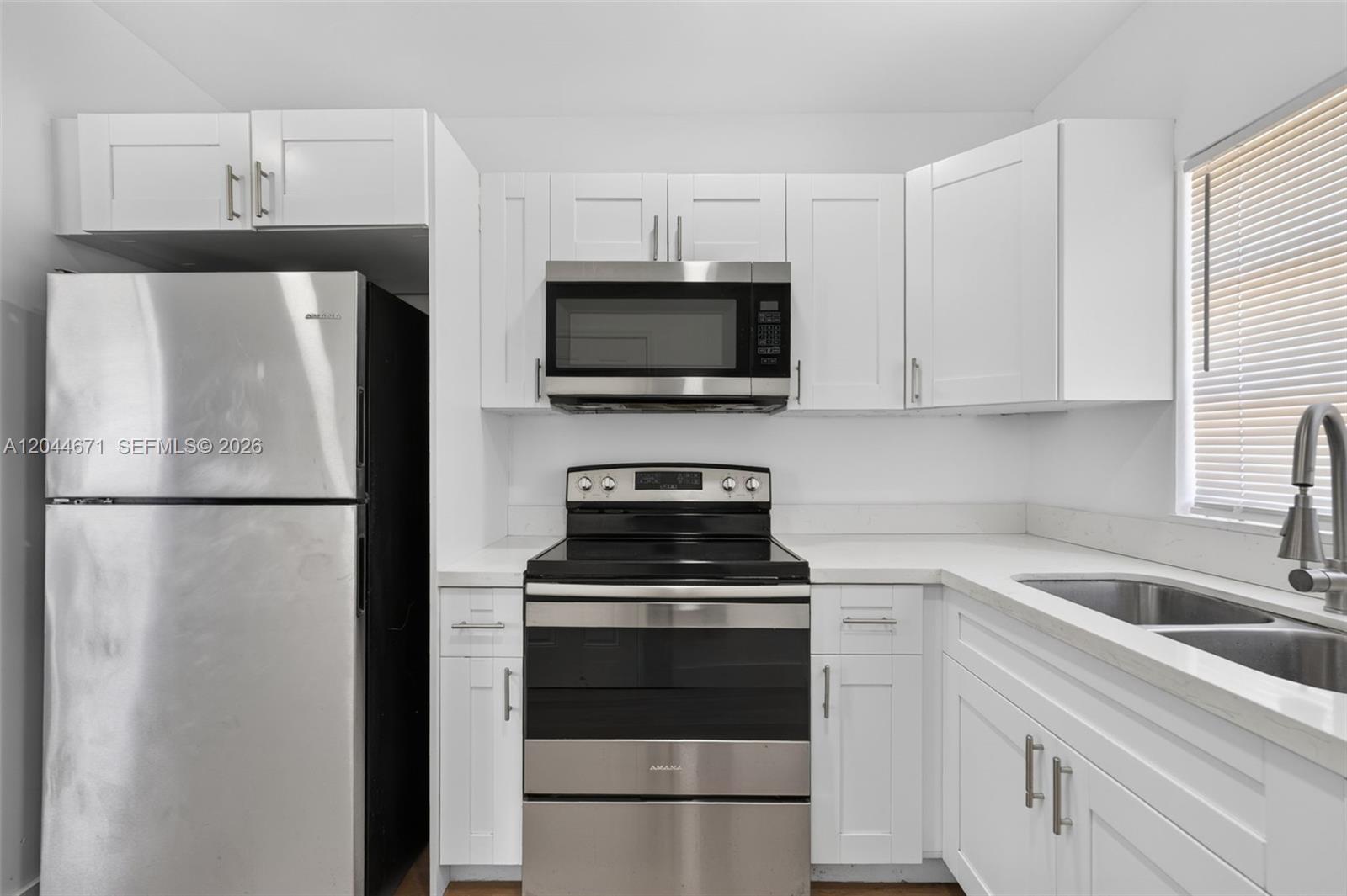A kitchen features white cabinets, stainless steel appliances, and a double-basin sink — 1900 SW 6th St SW 6th St # 6, Miami FL 33135, MIAMI, FL