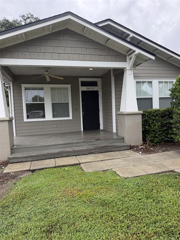 A gray house with a covered front porch, a black door, and a grass lawn — 3613 S SUMMERLIN AVENUE, ORLANDO, FL