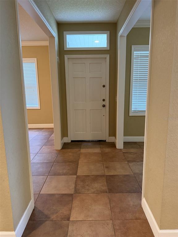 A tiled entryway features a white front door with a transom window and side openings — 3613 S SUMMERLIN AVENUE, ORLANDO, FL