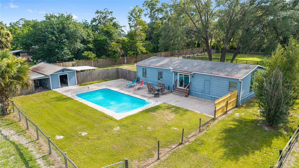 An aerial view of a blue house with a swimming pool and a detached garage — 3371 NW 120TH AVENUE, OCALA, FL
