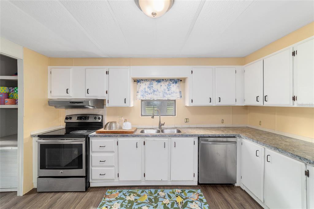 A kitchen features white cabinets, stainless steel appliances, a double sink, and light-colored walls — 3371 NW 120TH AVENUE, OCALA, FL