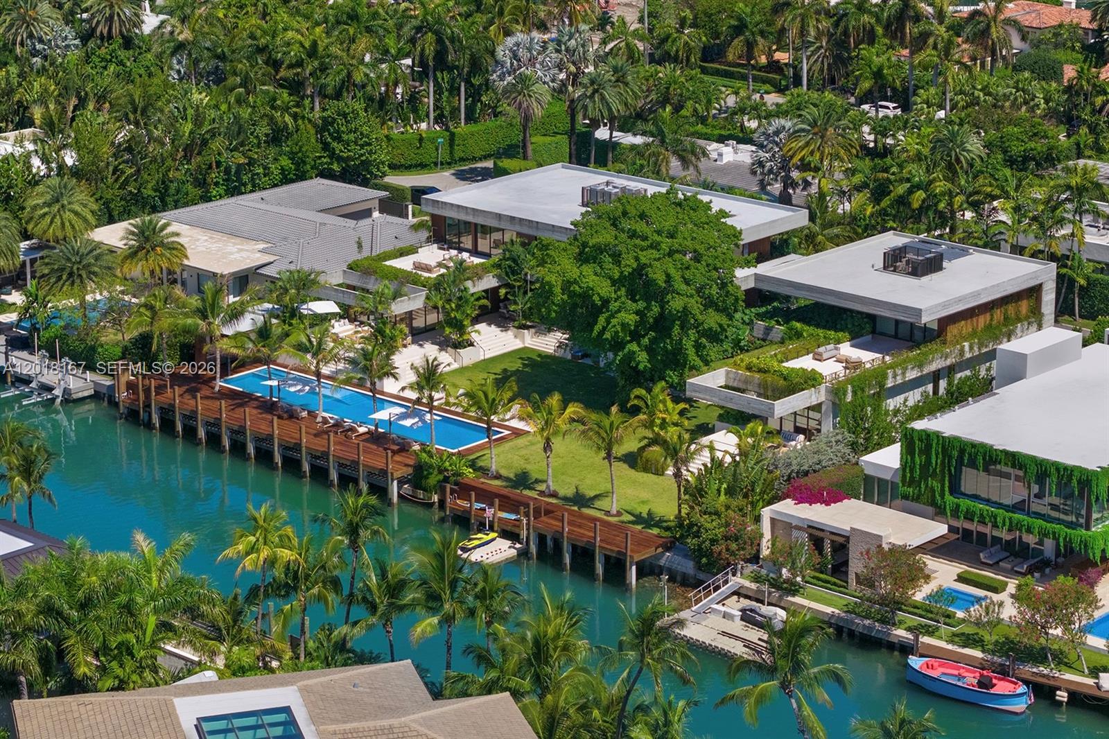 An aerial view shows a modern waterfront estate with a pool, dock, and lush landscaping — 1420 W 23rd St, Miami Beach FL 33140, MIAMI BEACH, FL