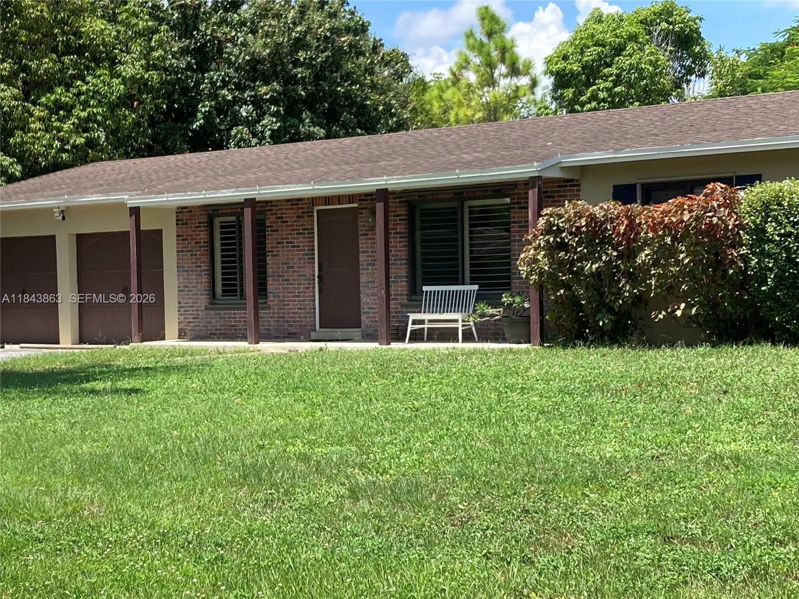 A single-story brick house features a garage, a front porch, and a large grassy lawn — 10801 SW 123rd St, Miami FL 33176, MIAMI, FL