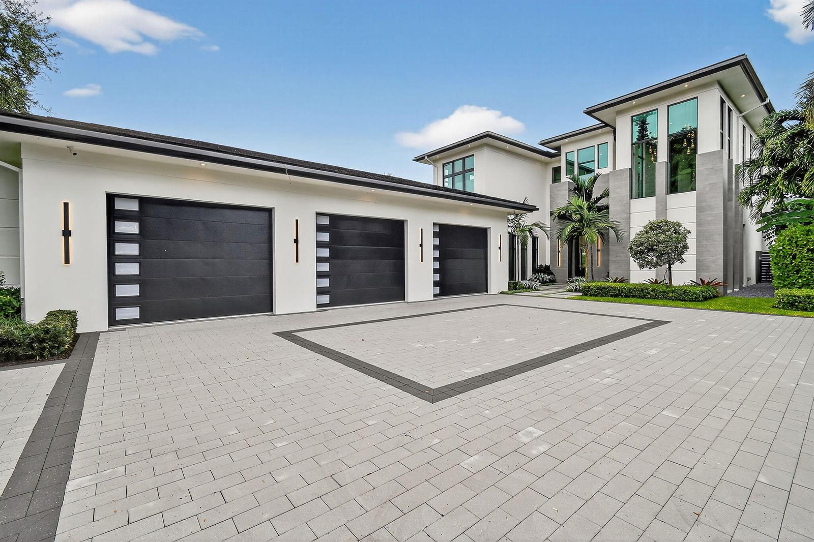 A modern two-story house features a three-car garage and a paved driveway — 2085 Vitex Lane, North Palm Beach FL 33408, NORTH PALM BEACH, FL