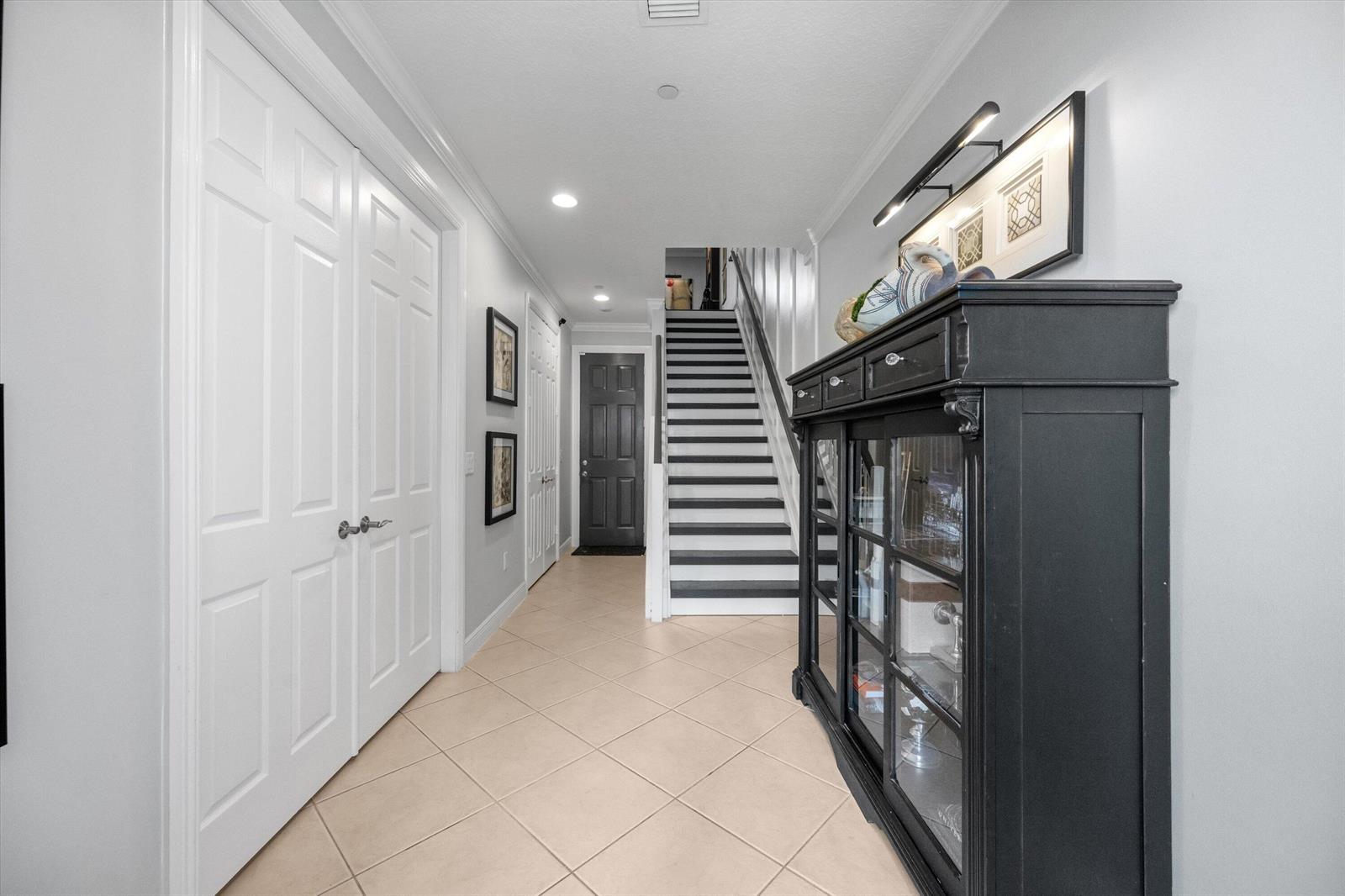 A hallway features tile flooring, a black display cabinet, and a staircase leading upward — 2502 N Dixie Highway # 52, FL 33460, FL