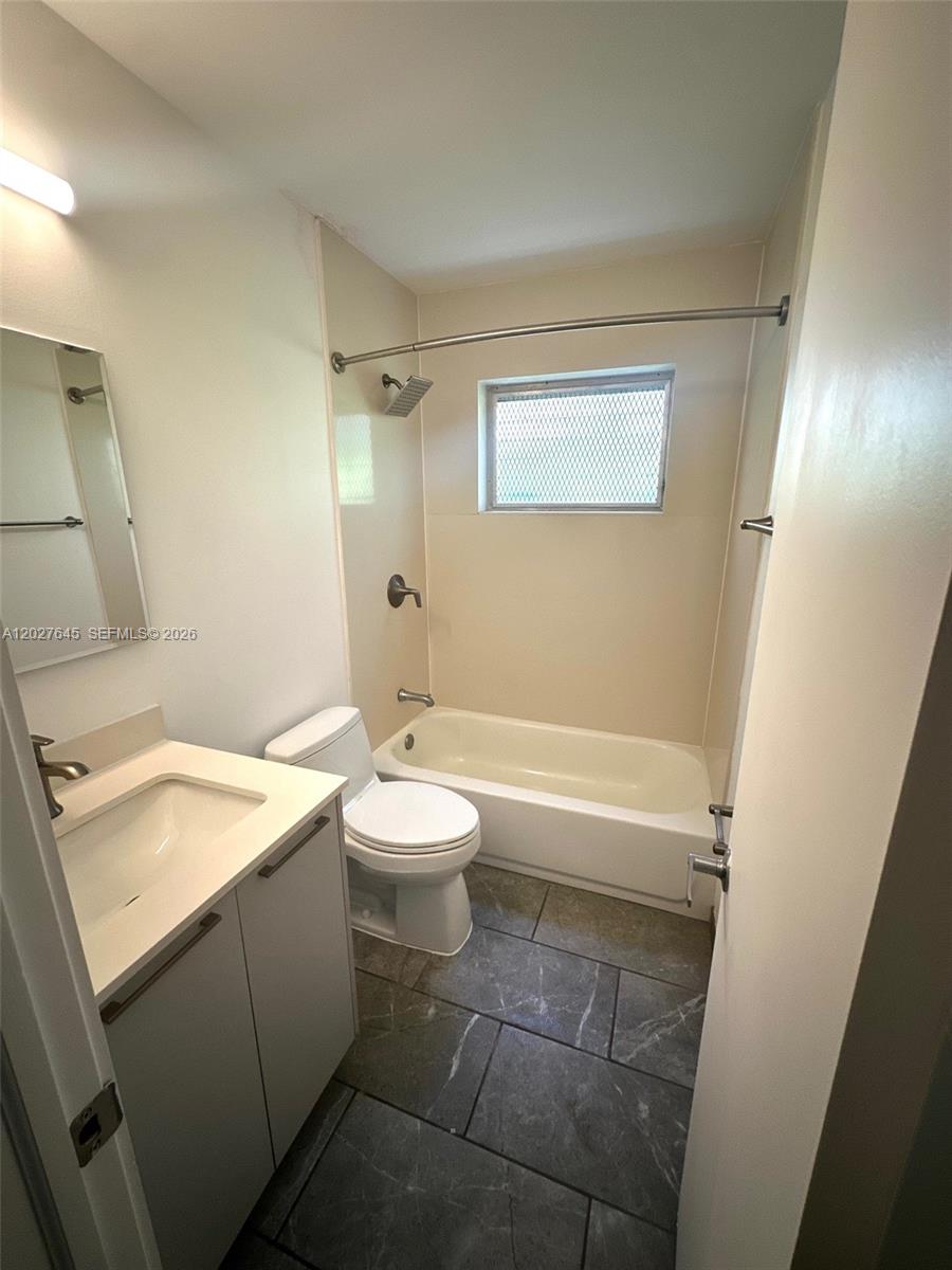 A bathroom features a vanity, a toilet, and a bathtub with a shower head — 710 Meridian Ave # 9, Miami Beach FL 33139, MIAMI BEACH, FL