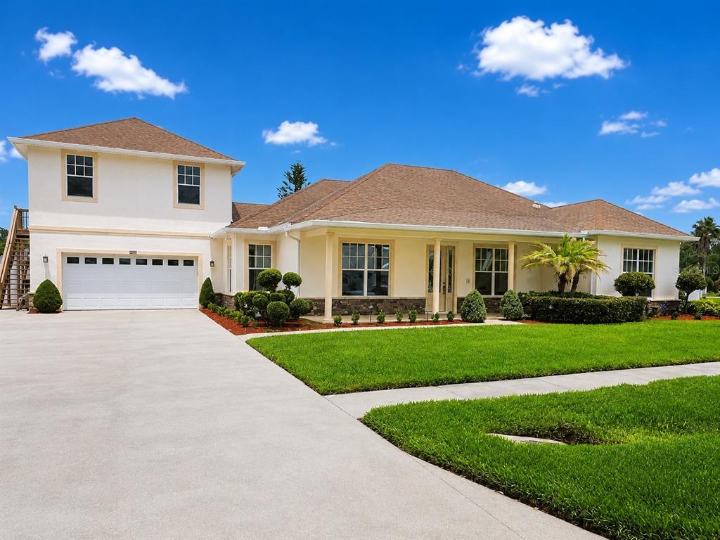 A two-story house with a white exterior, brown roof, and a large concrete driveway — 6402 BARCELLONA ROAD, LAND O LAKES, FL