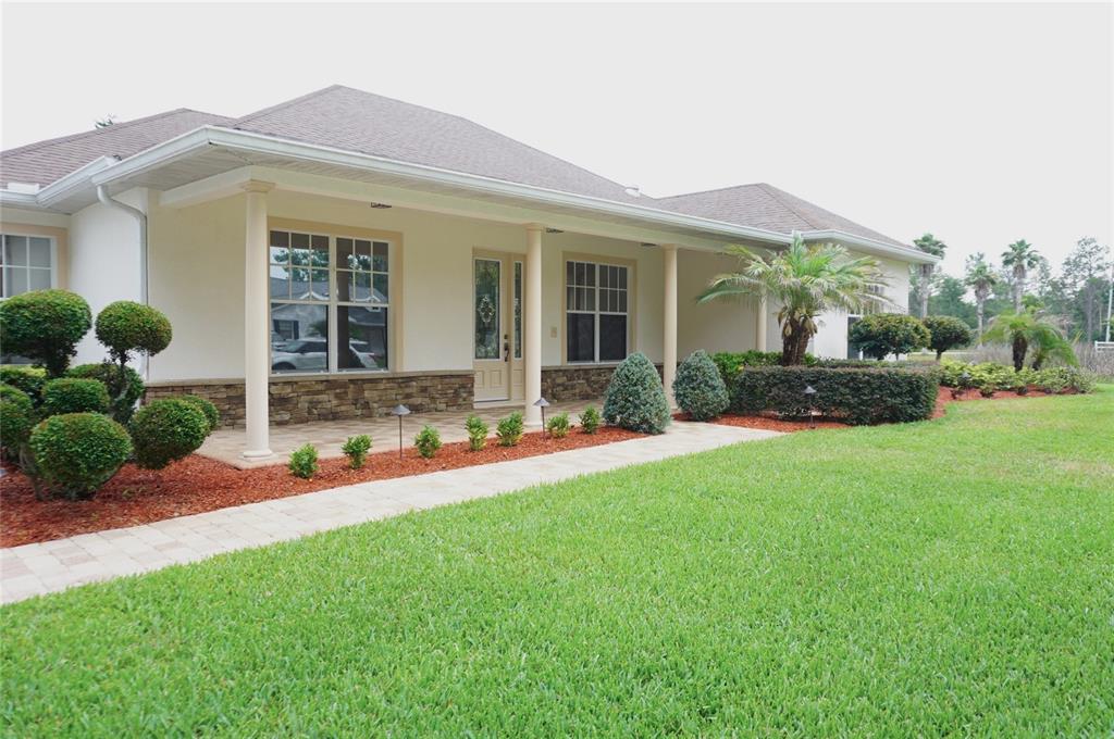 A single-story house with a covered porch, stone accents, and a manicured front lawn — 6402 BARCELLONA ROAD, LAND O LAKES, FL