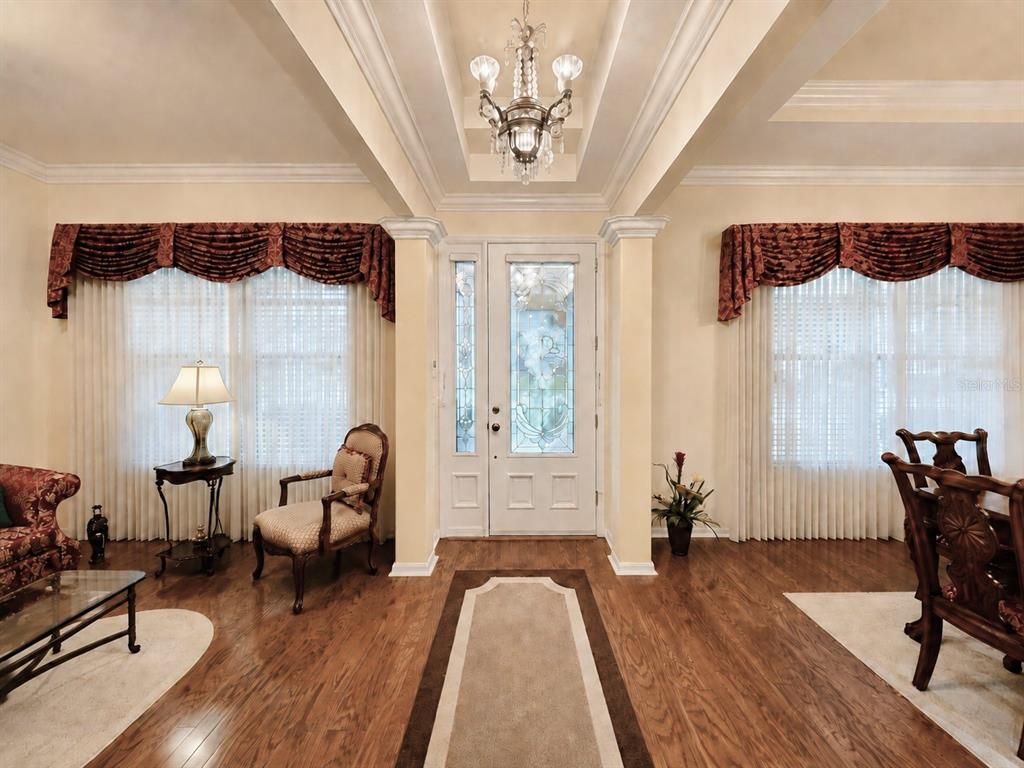 A living room features tan leather sofas, a wooden coffee table, and a wall-mounted television — 6402 BARCELLONA ROAD, LAND O LAKES, FL