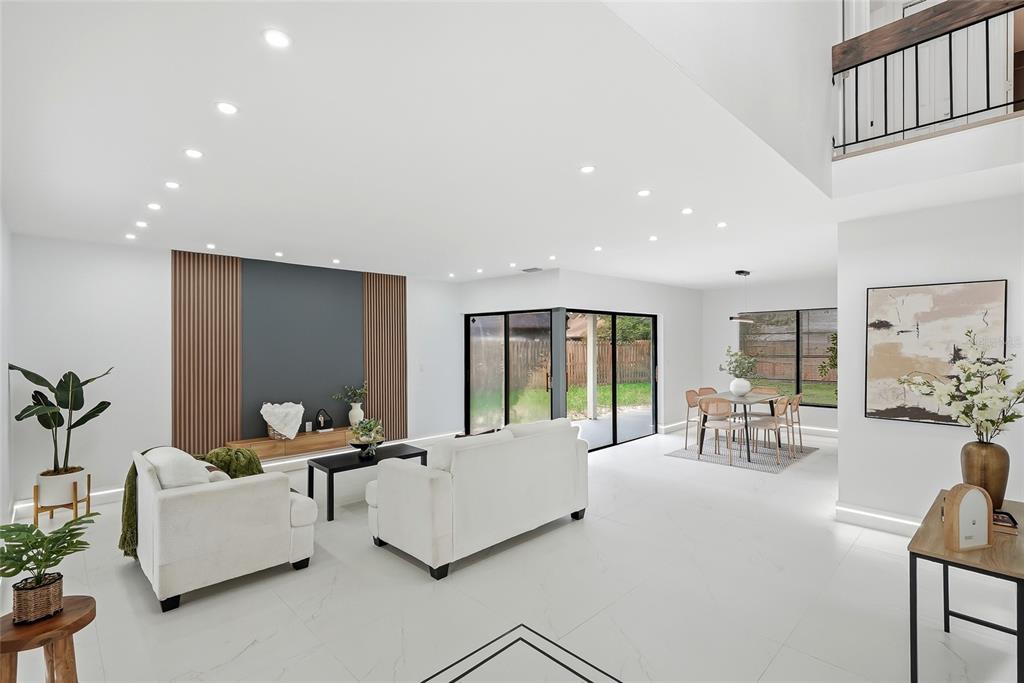 An open-concept living and dining area features white tile floors, recessed lighting, and wood accents — 4505 WHITWORTH LANE, TAMPA, FL