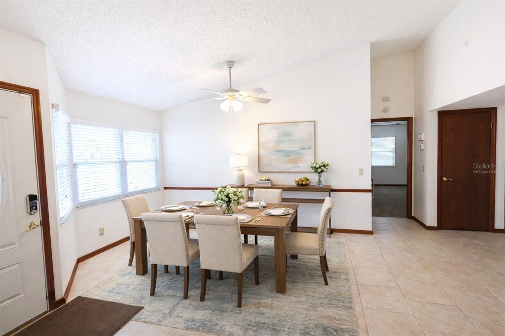 A dining room features a wooden table with six upholstered chairs on a patterned rug — 3924 CREWS LAKE DRIVE, LAKELAND, FL