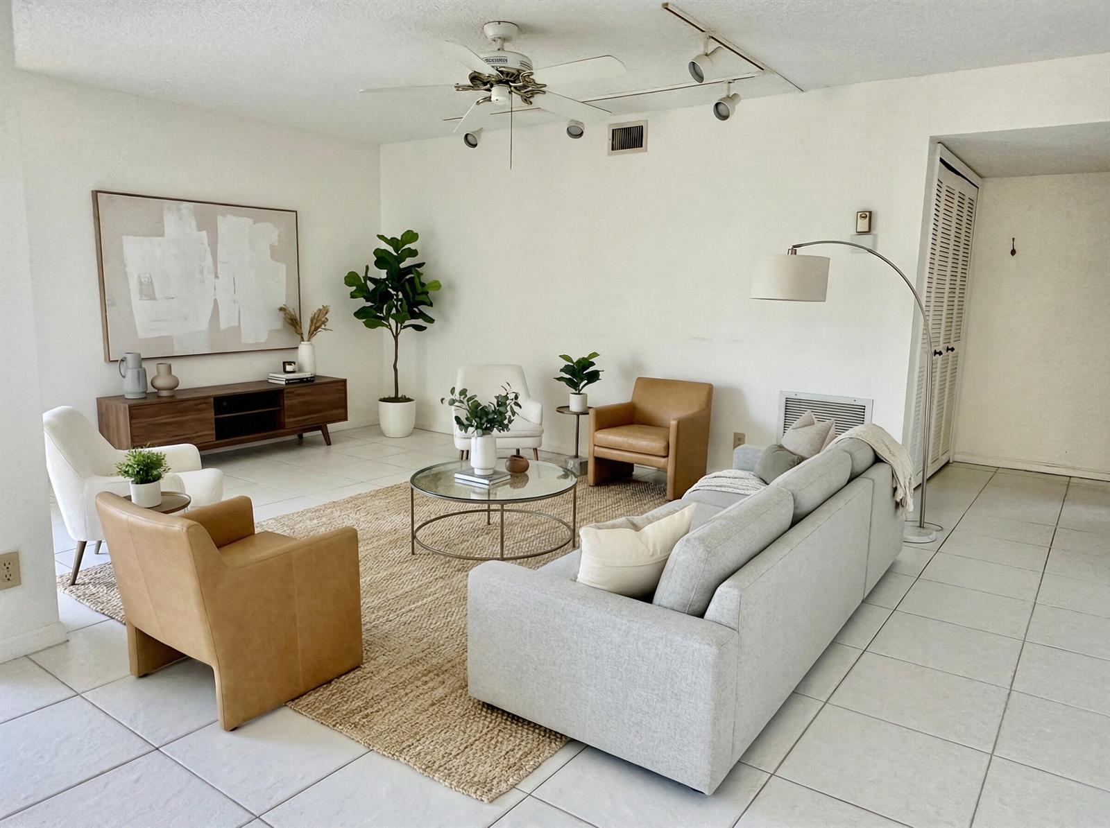 A living room features a grey sofa, leather armchairs, a coffee table, and tile flooring — 5819 Parkwalk Drive, Boynton Beach FL 33472, BOYNTON BEACH, FL