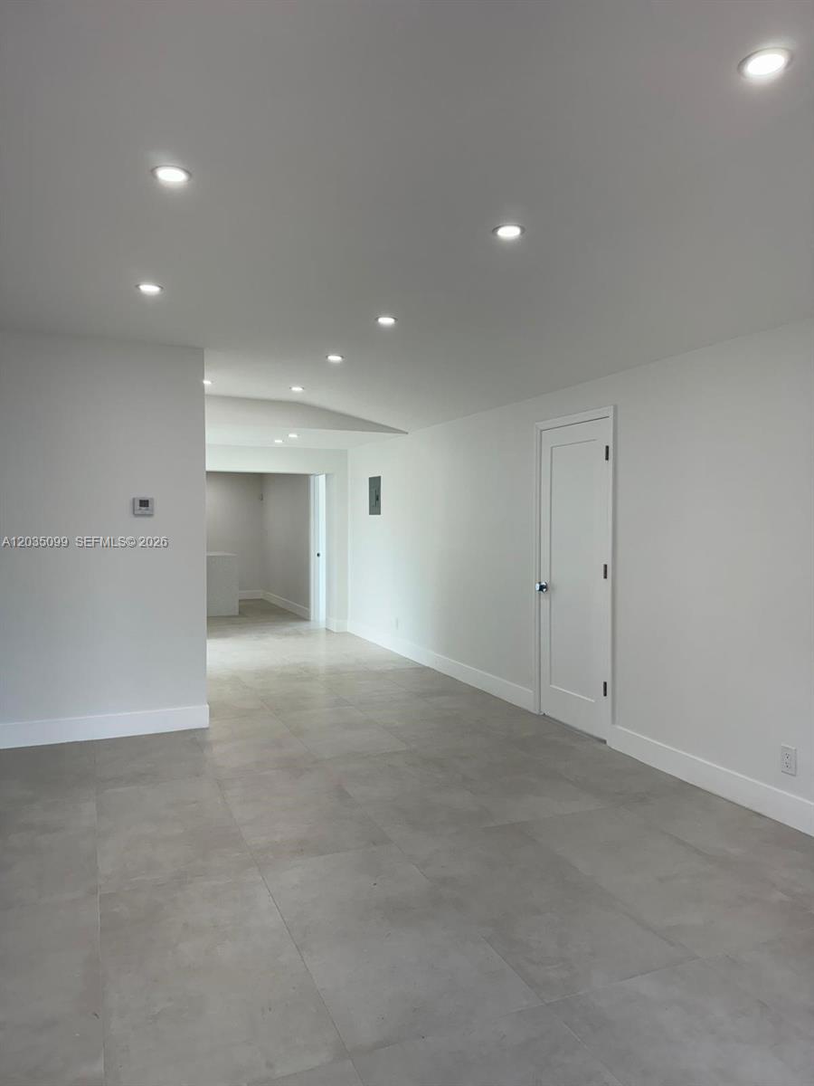A minimalist room features gray tile flooring, white walls, recessed lighting, and a closed door — 4028 SW 49th Ct, Dania Beach FL 33314, DANIA BEACH, FL