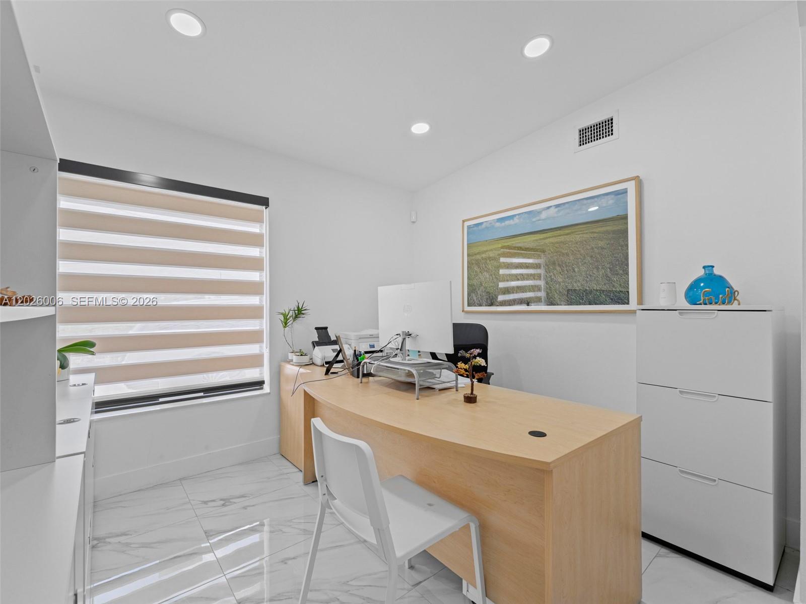 A home office features a light wood desk, white filing cabinet, and marble-look tile flooring — 10700 SW 46th St, Miami FL 33165, MIAMI, FL