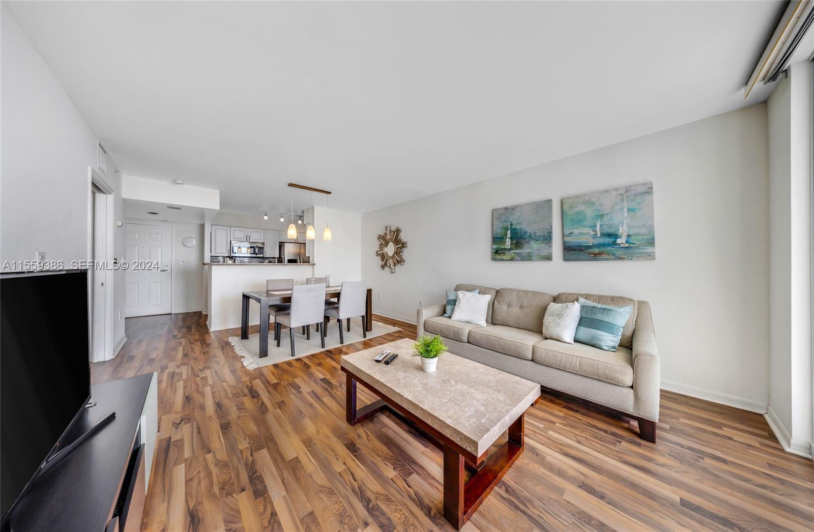 A living room and dining area feature wood-look flooring, a beige sofa, and a coffee table — 1155 Brickell Bay Drive Apt 2207, Miami FL 33131, MIAMI, FL
