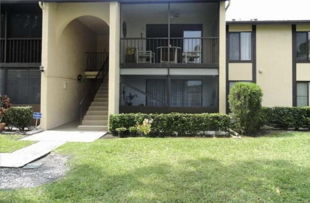 An exterior view of a two-story apartment building with screened balconies and an outdoor staircase — 814 Sky Pine Way # 2, FL 33415, FL