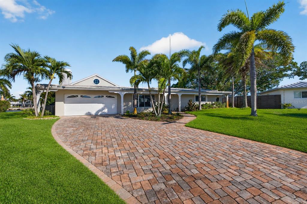 A single-story house with a brick paver driveway, palm trees, and a two-car garage — 1276 37TH AVENUE NE, ST PETERSBURG, FL