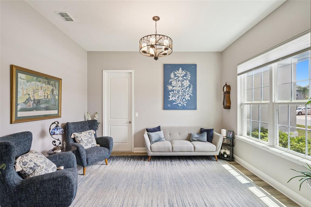 A living room features two blue armchairs, a light gray sofa, and a chandelier — 3113 PINENUT DRIVE, APOPKA, FL