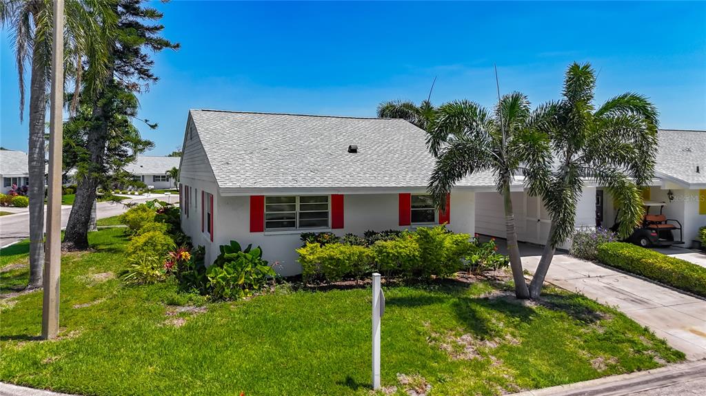 A single-story house with a white exterior, red shutters, and a palm tree in front — 4523 W INDEPENDENCE DRIVE, BRADENTON, FL