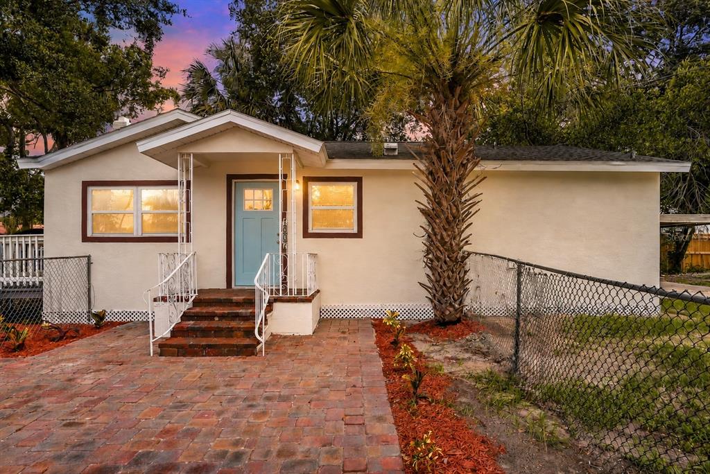 A single-story house with a light-colored exterior, a blue front door, and a brick walkway — 1002 E SEWARD STREET, TAMPA, FL