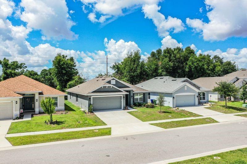 A street-level view shows three suburban single-story houses with garages and green lawns — 292 KRENSON BAY LOOP, WINTER HAVEN, FL