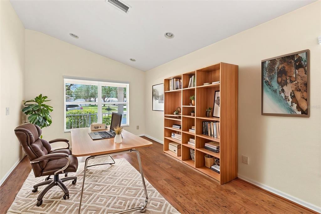 An empty living room features wood-look flooring, a vaulted ceiling, a chandelier, and a front door — 11331 COCONUT ISLAND DRIVE, RIVERVIEW, FL